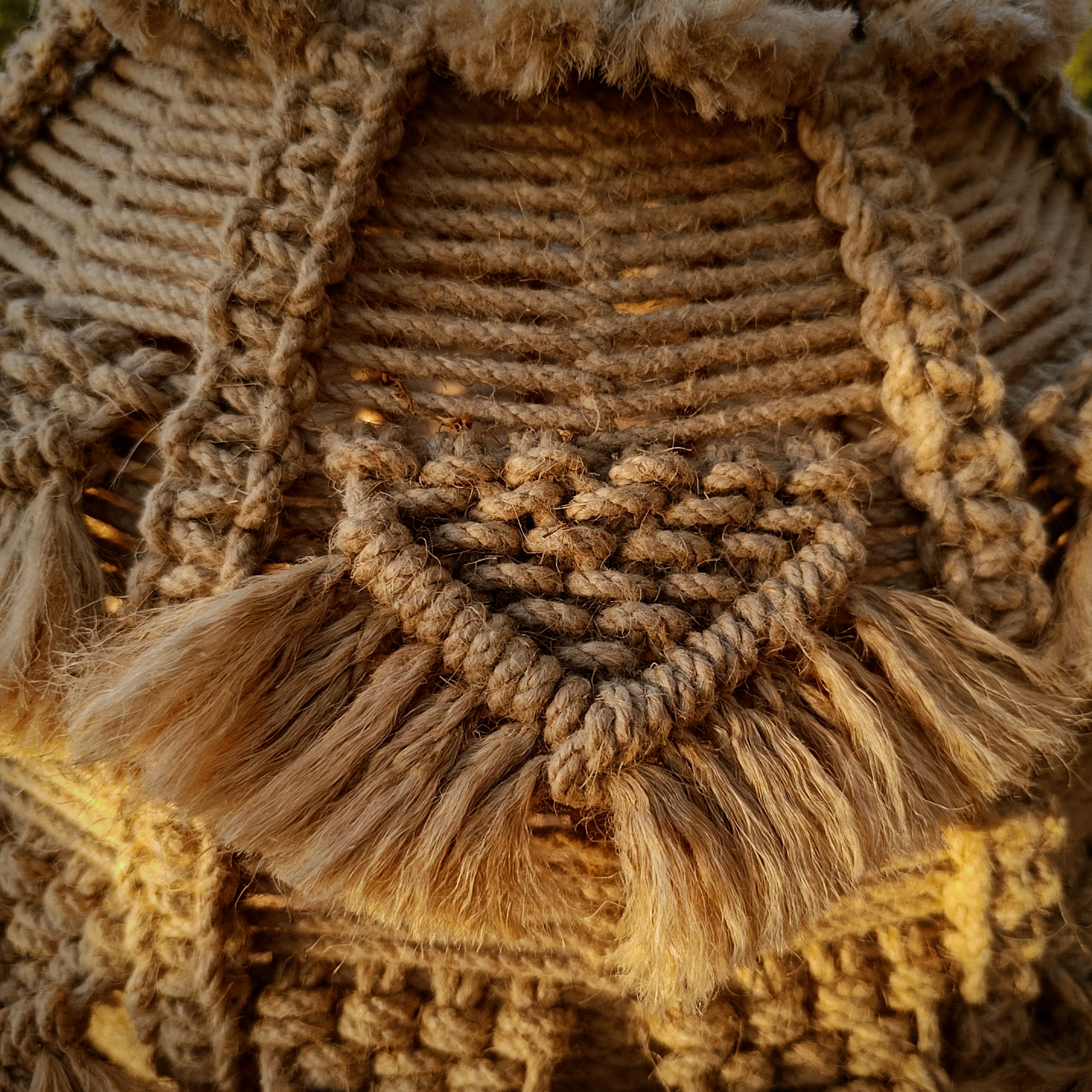 Close up photo of La Alma de Barro by Koko Bamboo, a hemp macramé lamp or chandelier with extensive accents as displayed in the fringes